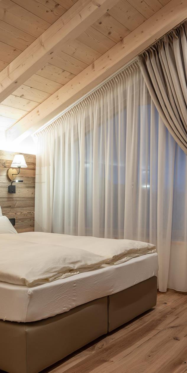 Der helle Schlafbereich mit Doppelbett von Ciasa Rosina