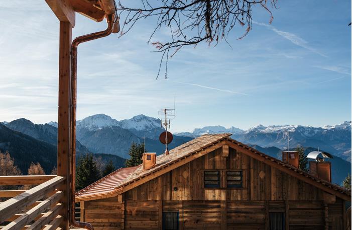 Holz-Chalets in den Dolomiten mit Blick auf die Berglandschaft.
