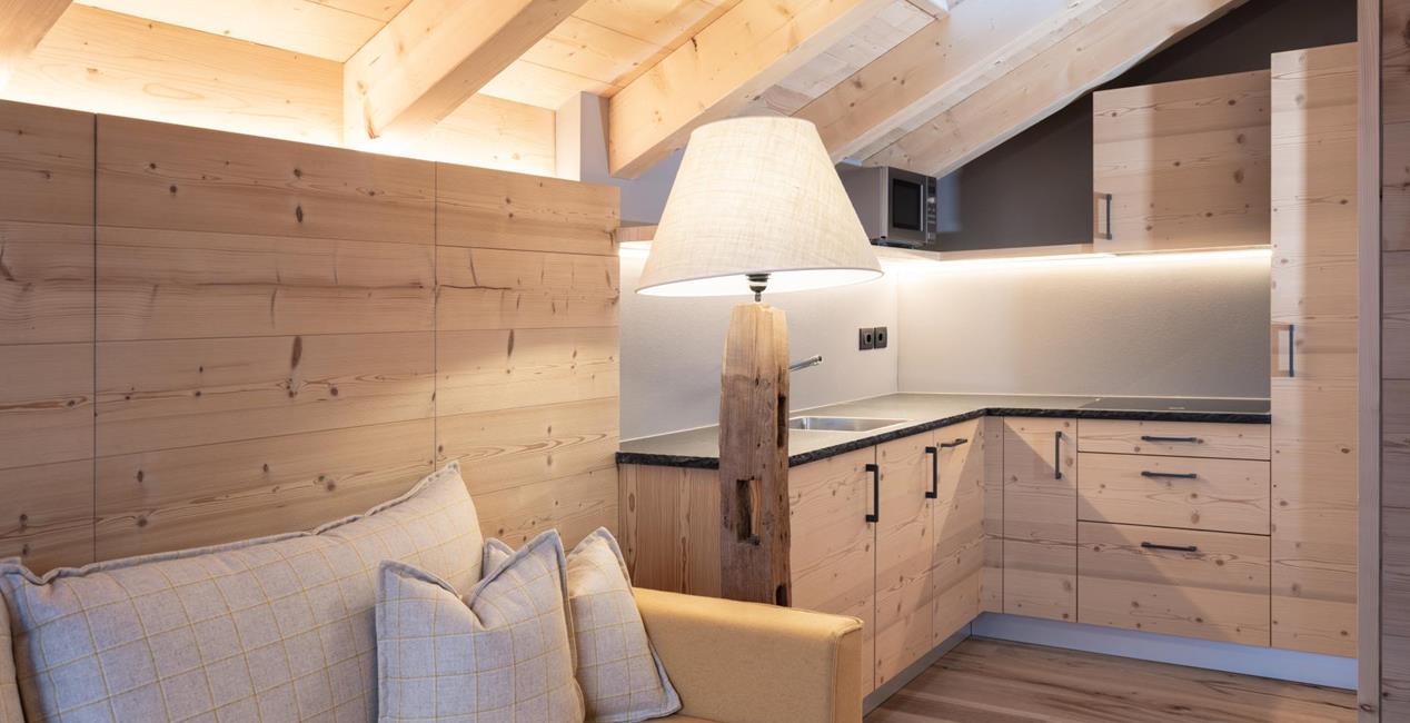Living and dining area with sofa and small kitchen area - Ciasa Arnica