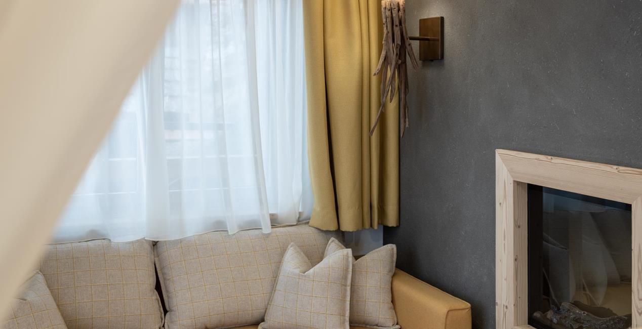 Living area with couch and fireplace - Ciasa Arnica