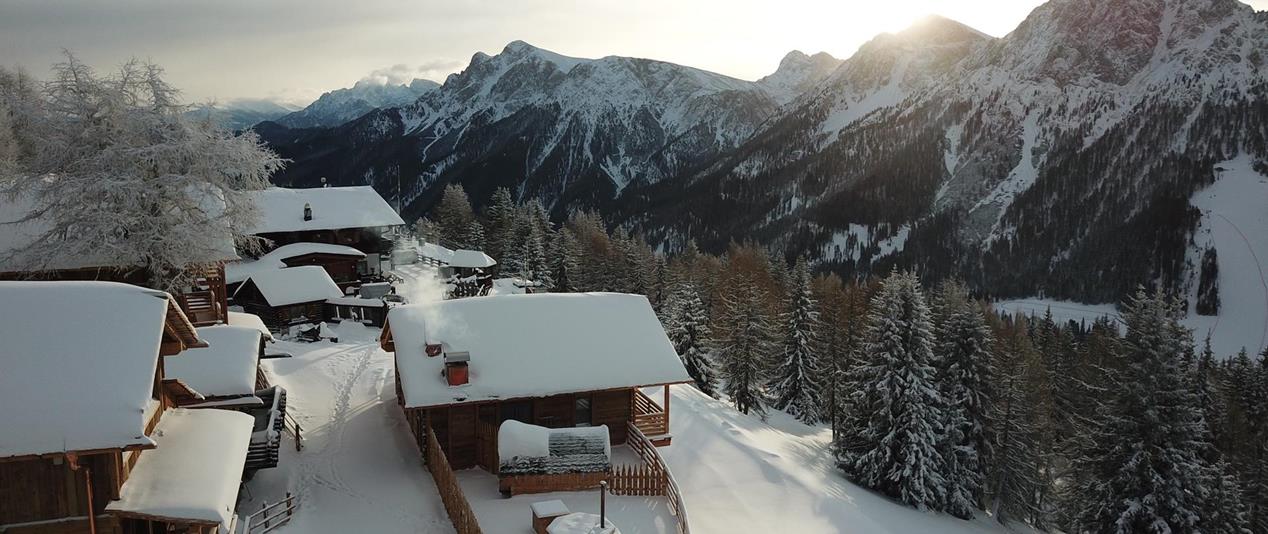 The chalets in winter with views of the snow-covered Dolomites.