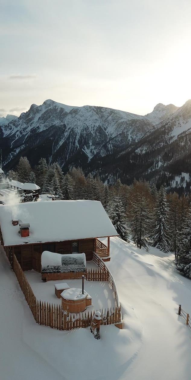 The chalets in winter with views of the snow-covered Dolomites.