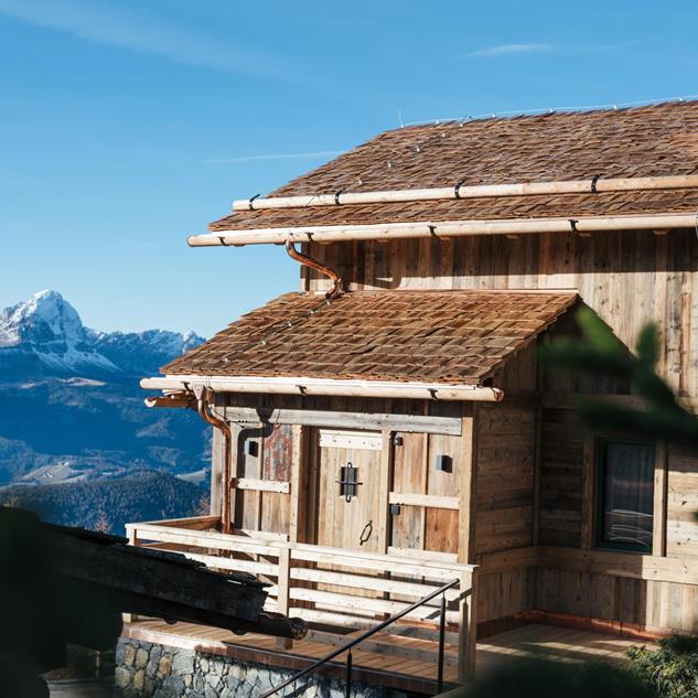 Chalet mit Blick in die Dolomiten und den blauen Himmel.