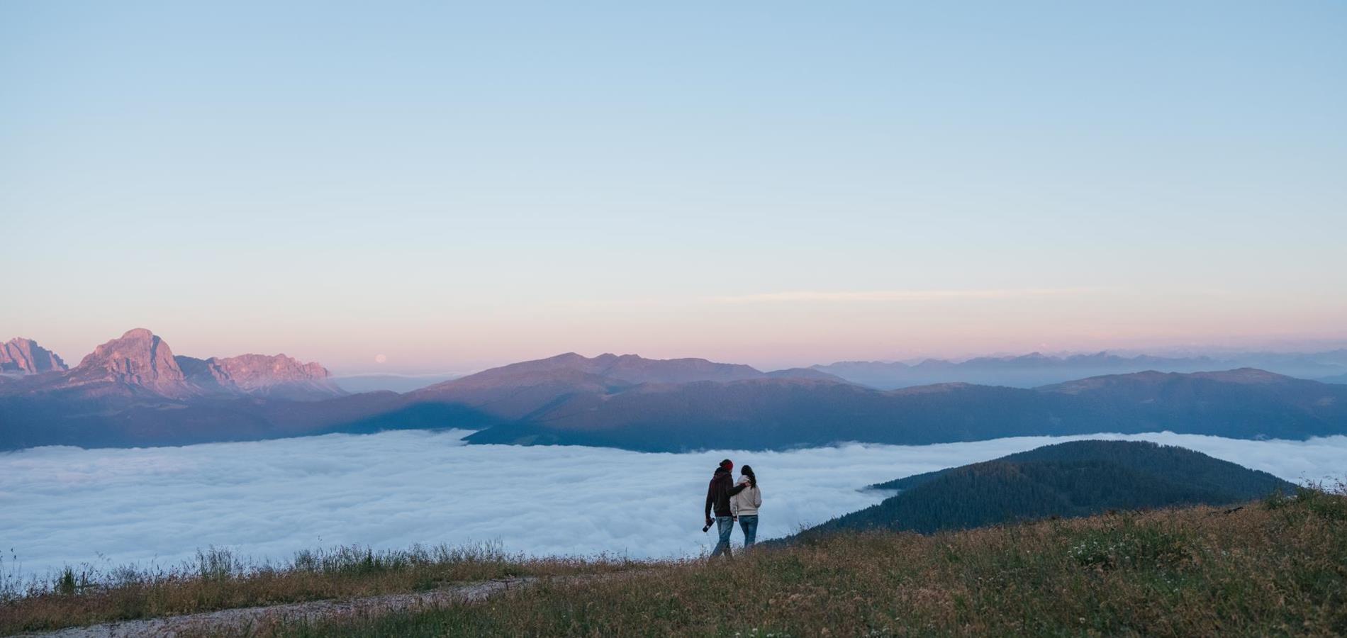 A couple hiking with a mountain landscape in the background.