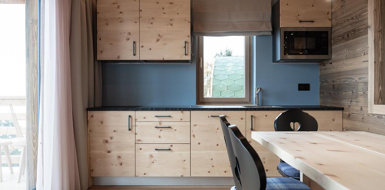 Kitchennete mit hellen Holzmöbeln in der Ciasa Grazia