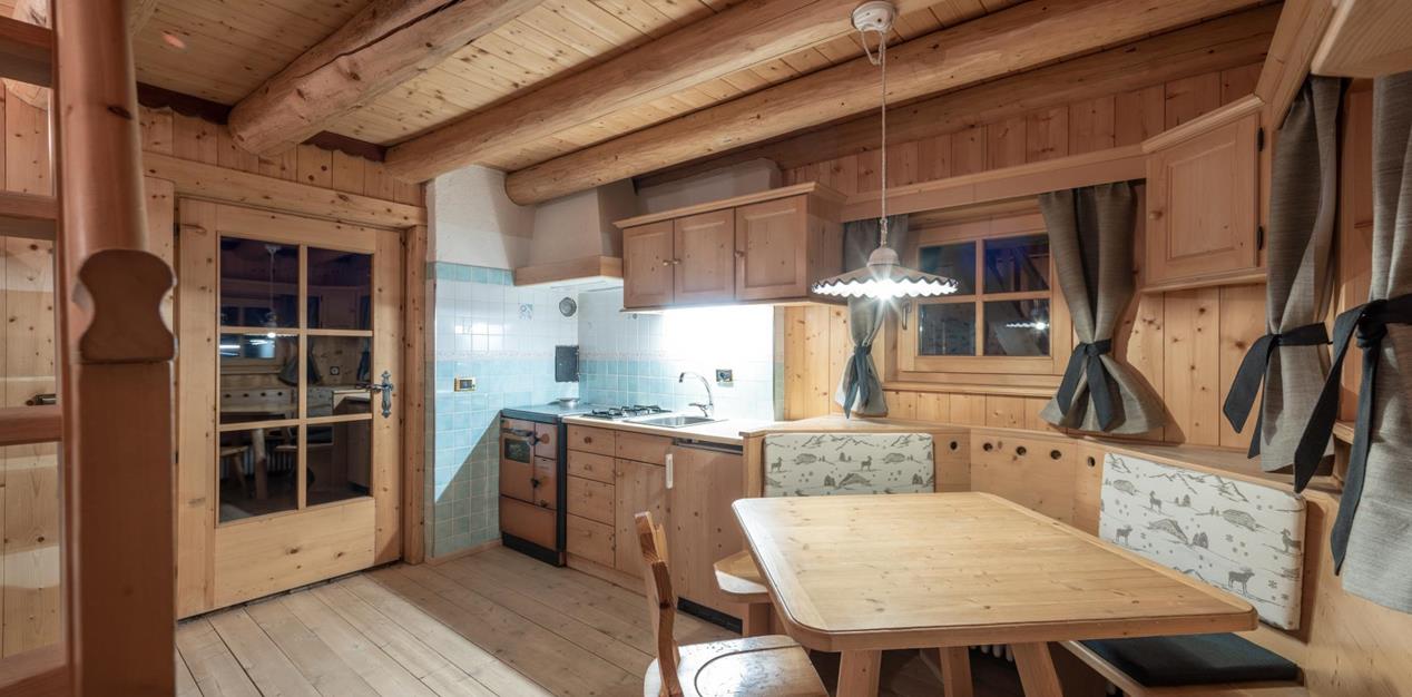 Wohn- und Essbereich der Ciasa Vedla mit Holzküche, Eckbank und Holztisch