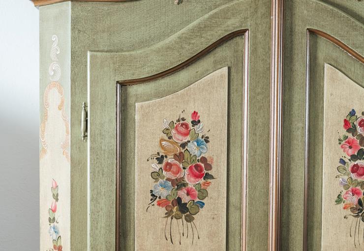 Ein grüner mit Blumen bemalter Schrank