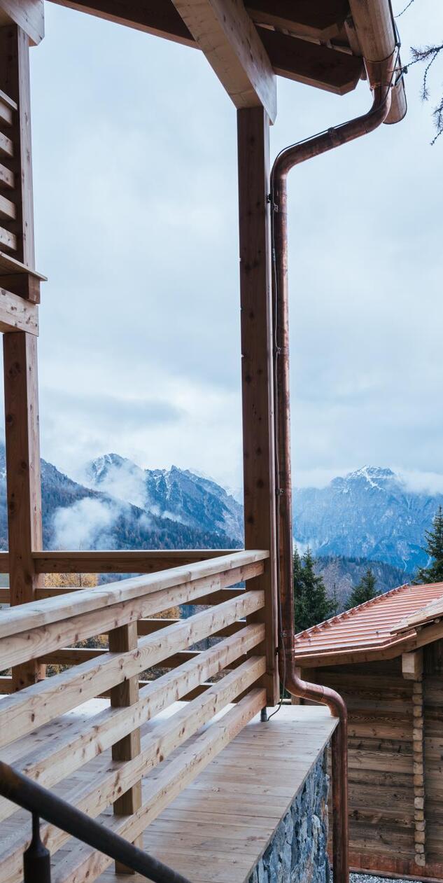 Aussicht vom Balkon eines Chalets auf die umliegende Berglandschaft.