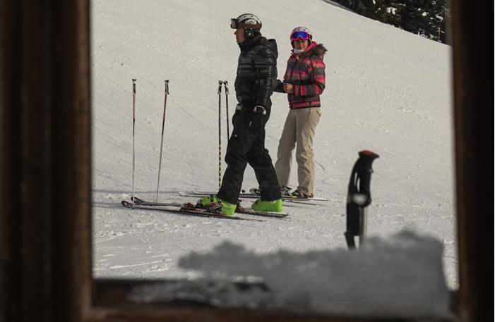 Zwei Skifahrer auf einer verschneiten Piste.