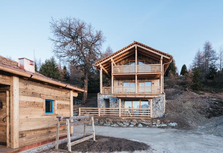 Chalets mit Nadelwald im Hintergrund.