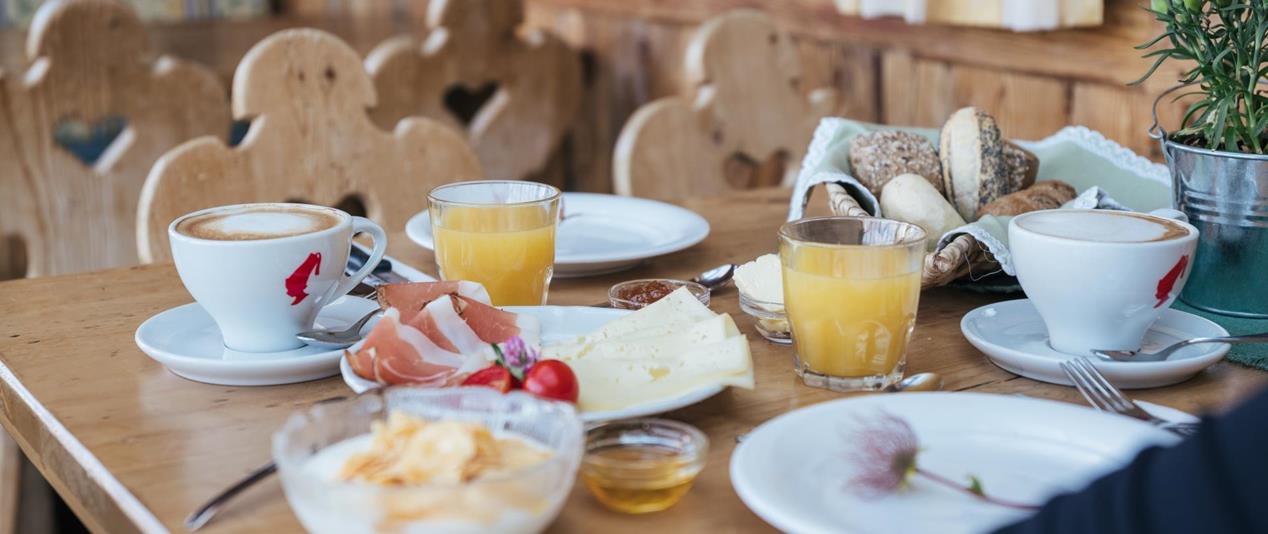 Frühstück mit herzhaften und süßen Speisen auf einem rustikalen Holztisch.