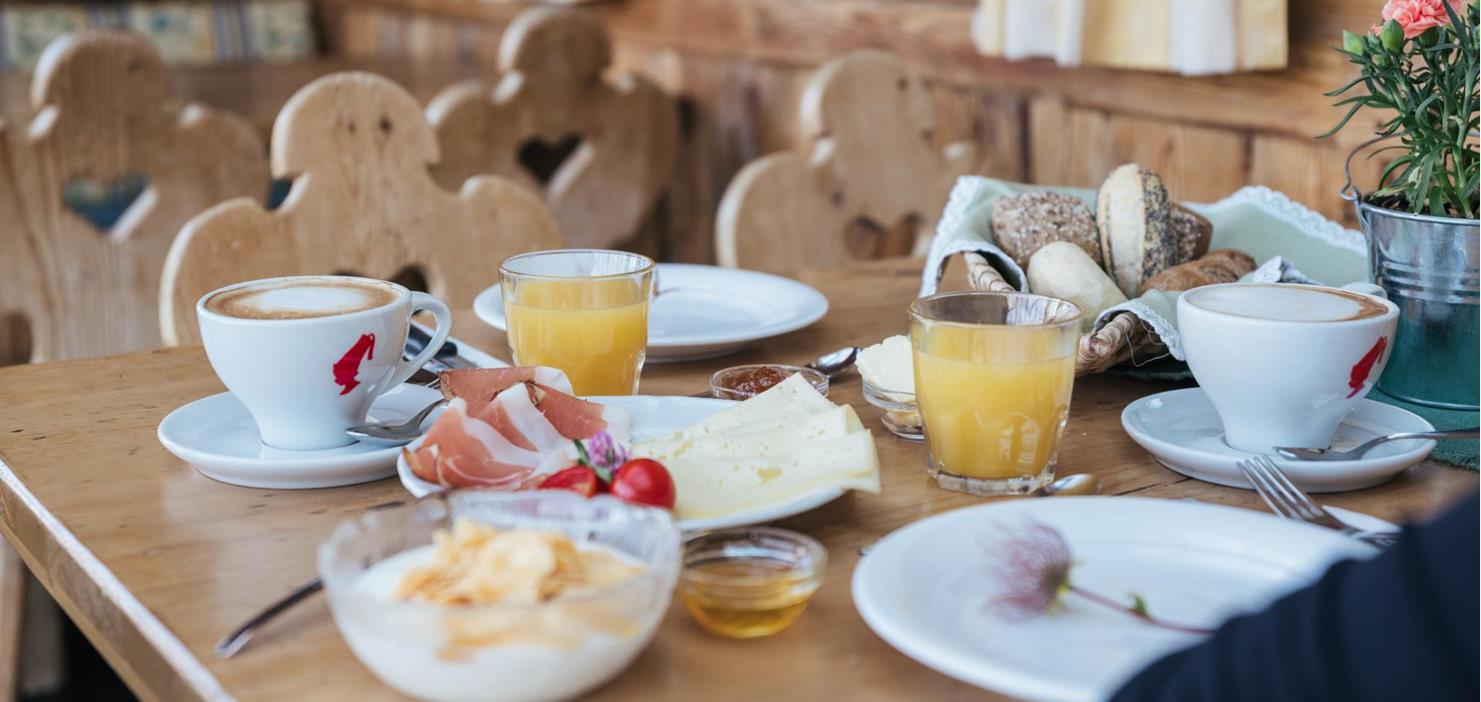 Frühstück mit herzhaften und süßen Speisen auf einem rustikalen Holztisch.