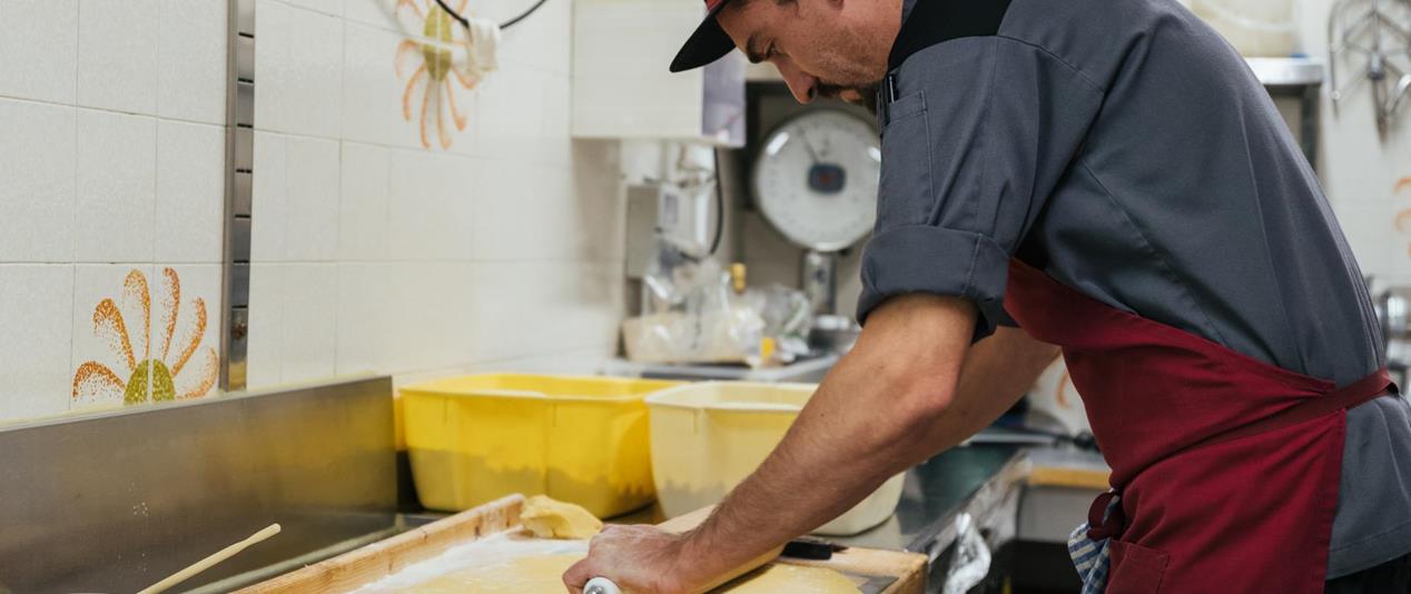 A chef rolling out dough.