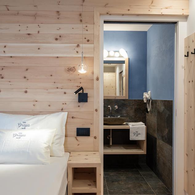 Ein helles Schlafzimmer mit angeschlossenem Badezimmer - Ciasa Grazia