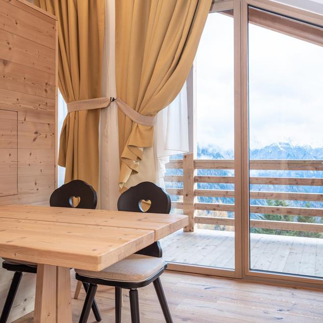 Wohnbereich mit hellen Holzmöbeln und Balkon - Ciasa Arnica